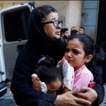 Seorang wanita dan anak-anak Palestina terlihat menangis setelah serangan udara Israel, di Khan Younis di Jalur Gaza selatan, 14 Oktober 2023. Foto: Reuters